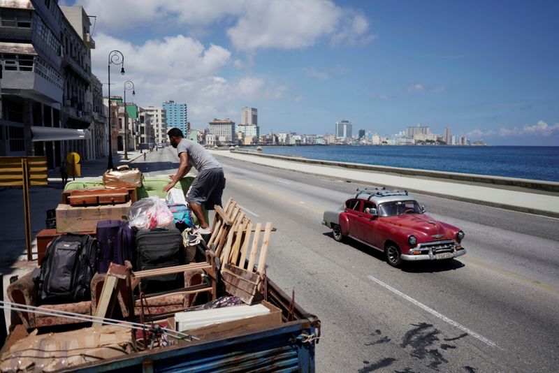 A man loads a truck with furniture from his home