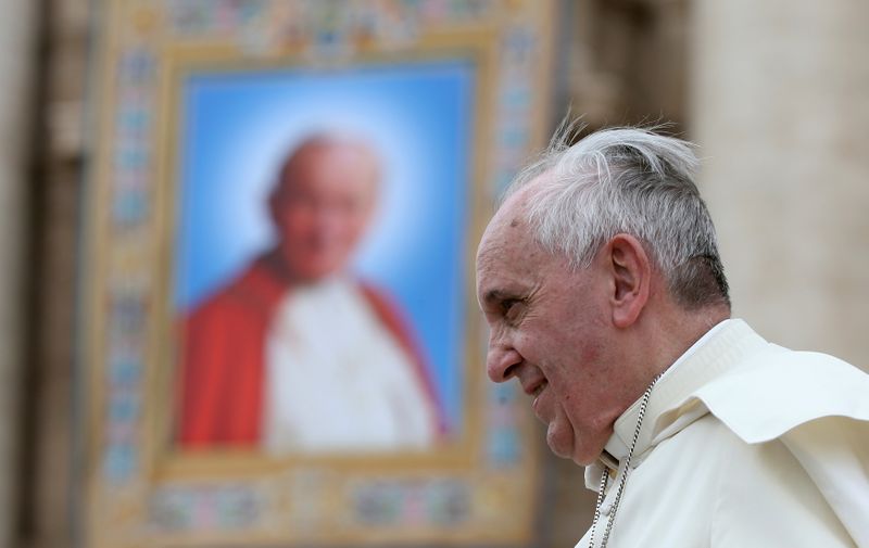 FILE PHOTO: Pope Francis passes next to a tapestry of