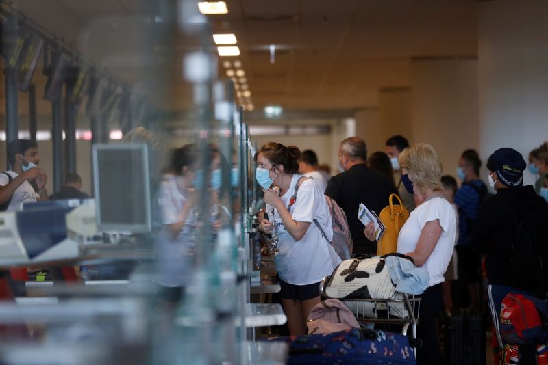FILE PHOTO: People queue at check in desks at Faro