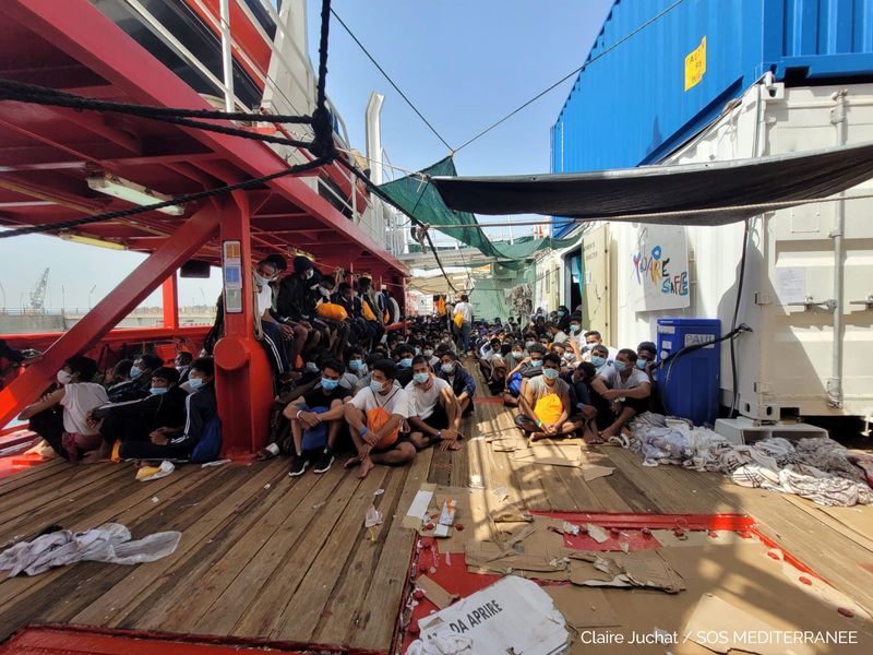 Migrants sit onboard “Ocean Viking” ship as they wait to