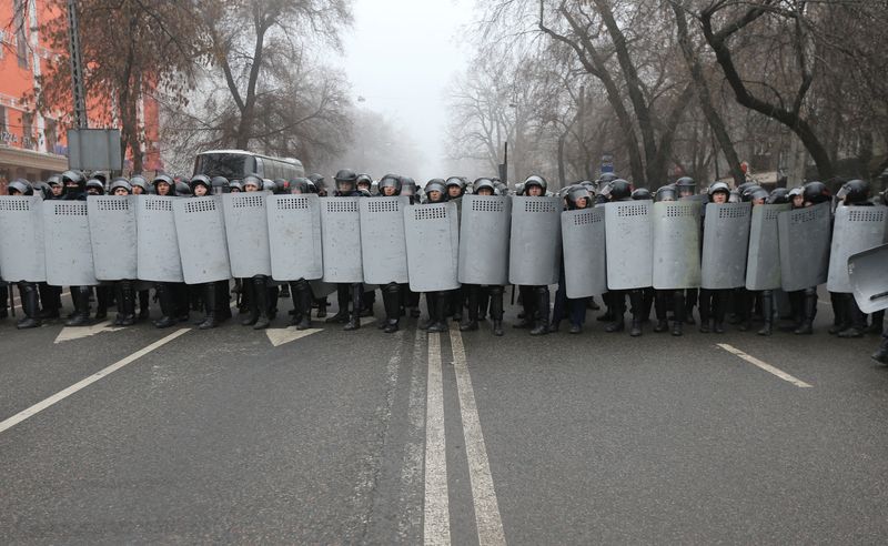 Kazakh law enforcement officers block a street during a protest