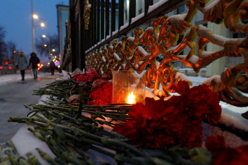 A candle and flowers are placed outside the Kazakh Embassy