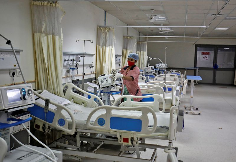 Staff member cleans medical equipment inside ward set up for