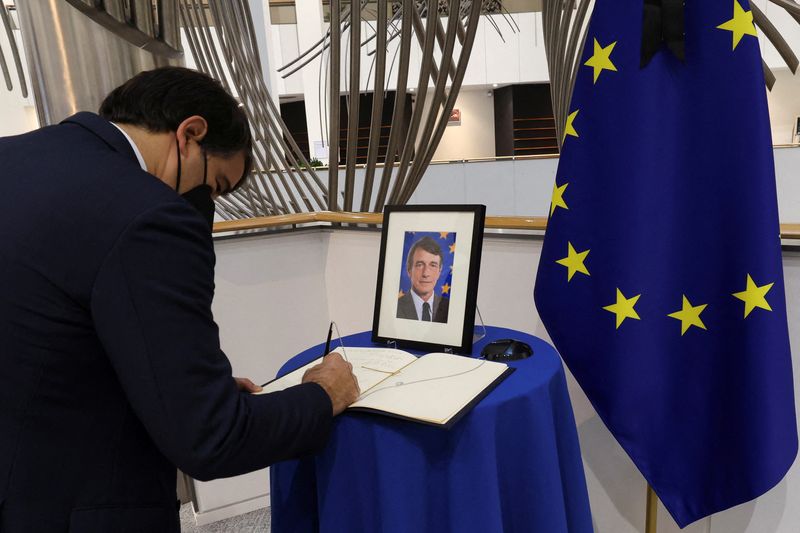 Man signs into a condolence book for late EU Parliament