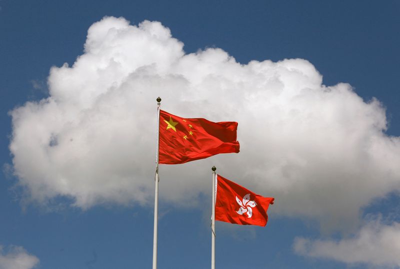 A Chinese national flag and a Hong Kong flag fly