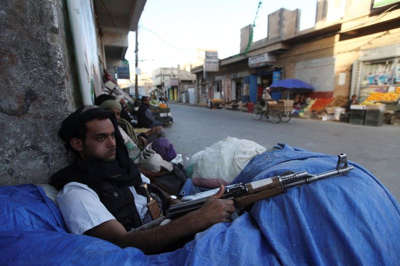 FILE PHOTO: A Shi’ite Houthi fighter sits behind sandbags near