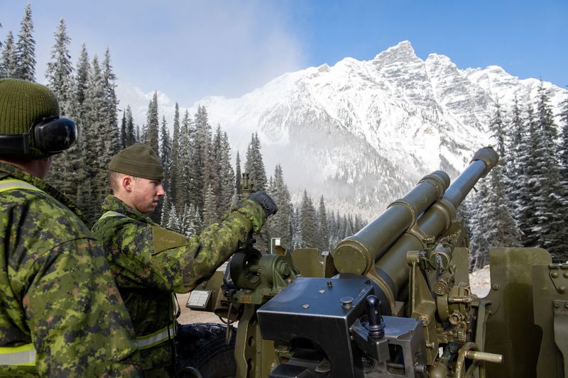 Gunners from Royal Canadian Artillery fire howitzer at snow pack
