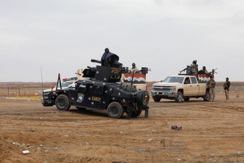 Vehicles of the Iraqi security forces gather near the Iraqi-Syrian