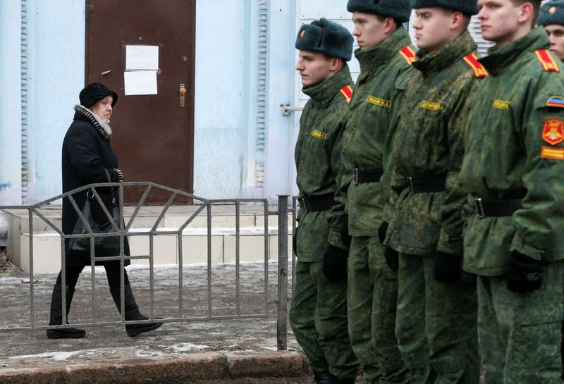 FILEPHOTO: A woman walks past cadets of the self-proclaimed Donetsk