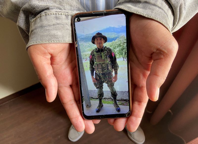 Kaung Thu Win shows a photograph of himself wearing an