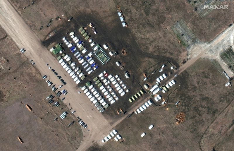 A satellite image shows a close-up of troops and equipment