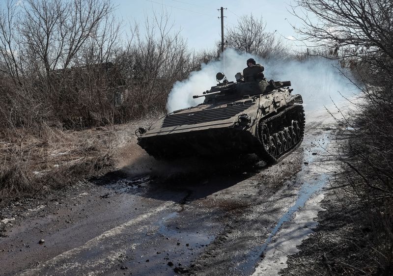 Ukrainian service members ride at a infantry fighting vehicle on