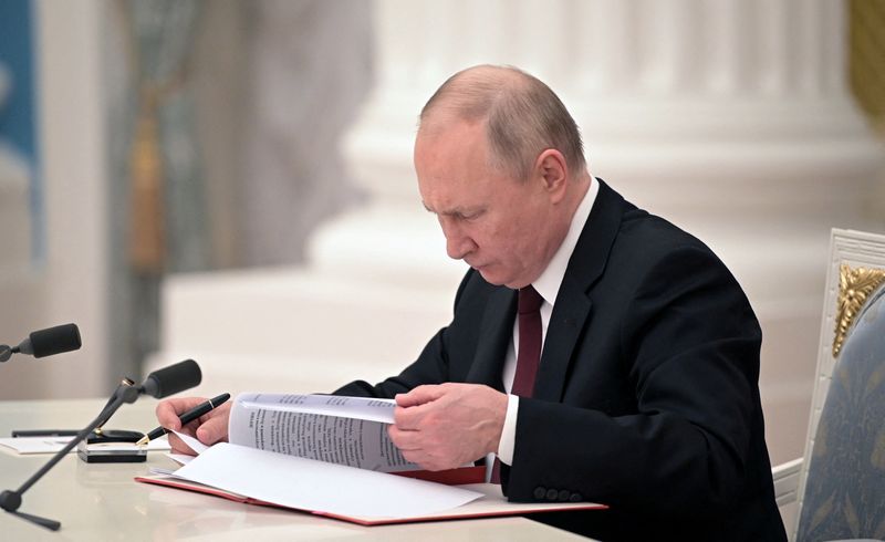 Russian President Vladimir Putin signs a decree recognising two Russian-backed