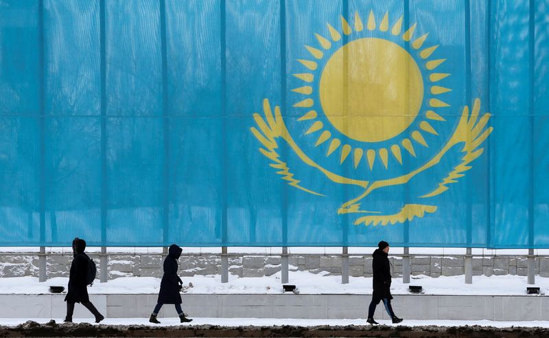 FILE PHOTO: People walk past a gaint Kazakhstan flag in