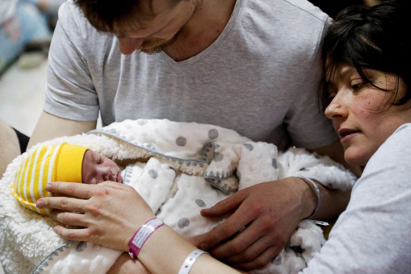 A couple with their newborn baby take shelter in the