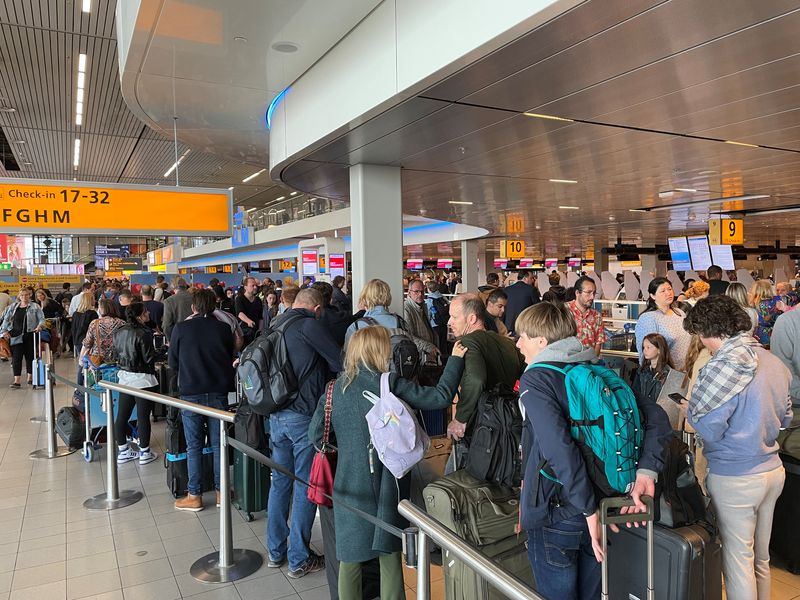 Long lines of waiting travellers at Amsterdam Schiphol Airport due