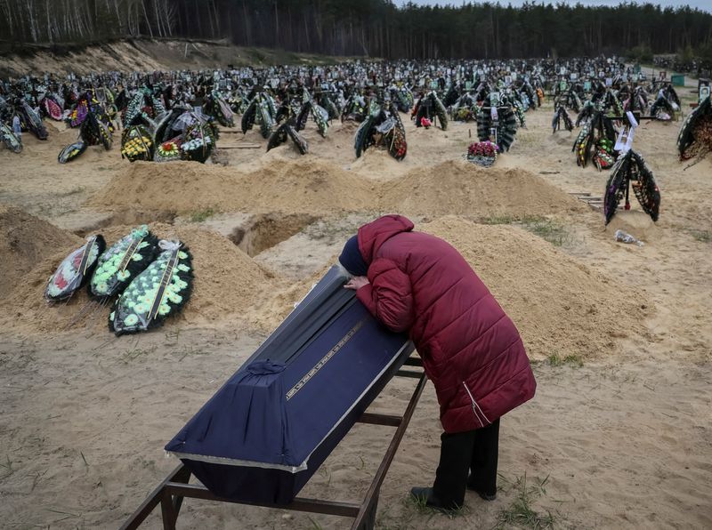 A woman reacts during a funeral of her relative, who
