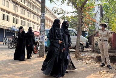 FILE PHOTO: Hijab wearing schoolgirls arrive to attend their classes