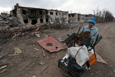 FILE PHOTO: A woman pushes a trolley with her belongings