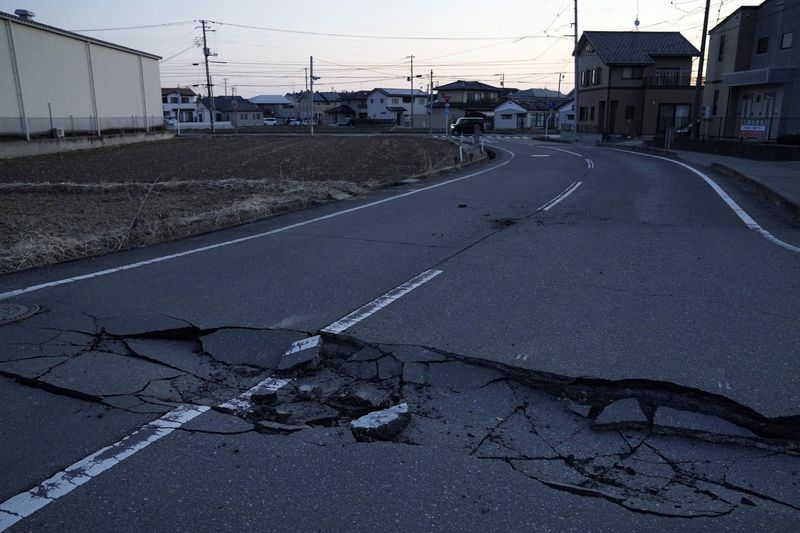 A broken road following a strong earthquake is pictured in