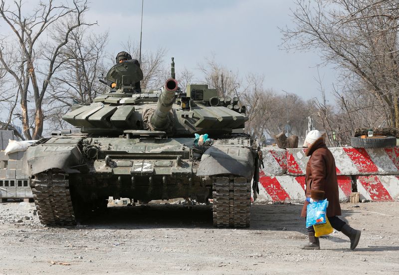 A local resident walks past a tank of pro-Russian troops