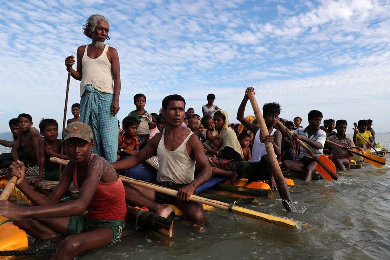 FILE PHOTO: Rohingya refugees cross the Naf River with an