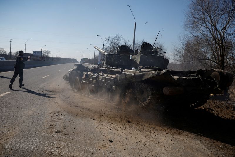 FILE PHOTO: A Ukrainian soldier directs a Russian tank that