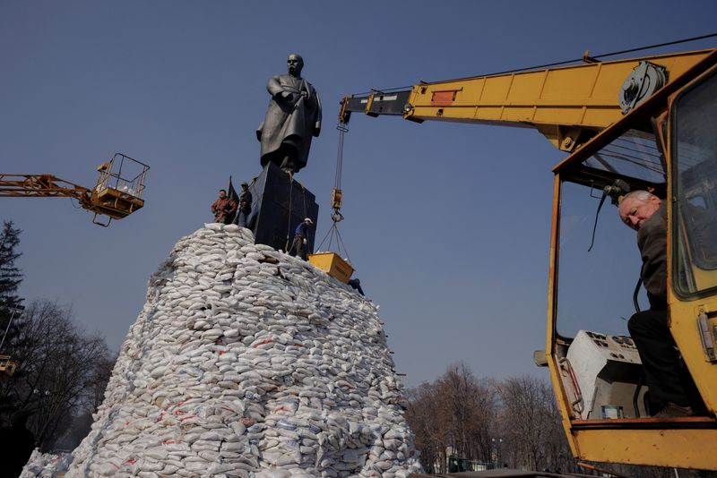 People pile up sand bags around monument to Ukrainian poet