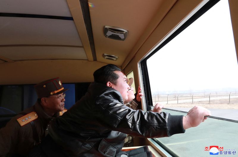 North Korean leader Kim Jong Un looks through a window
