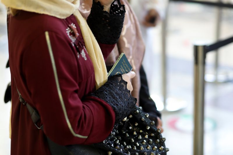 FILE PHOTO: Afghan woman holds her passport at the international