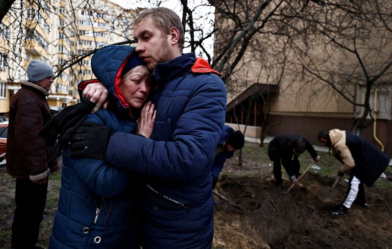 Serhii Lahovskyi hugs Ludmyla Verginska as they mourn their common