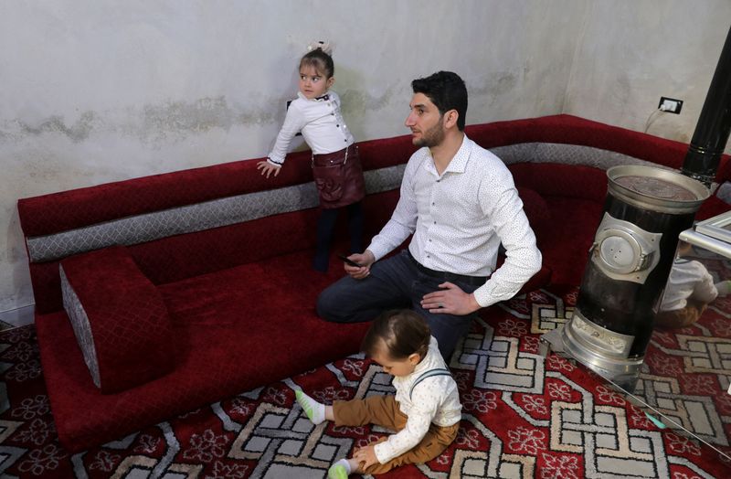 Abdel Hamid al-Youssef sits with his children at his home