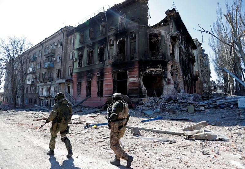 FILE PHOTO: Service members of pro-Russian troops inspect streets of