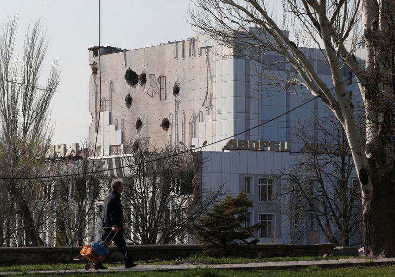 A local resident walks past the damaged Palace of Culture