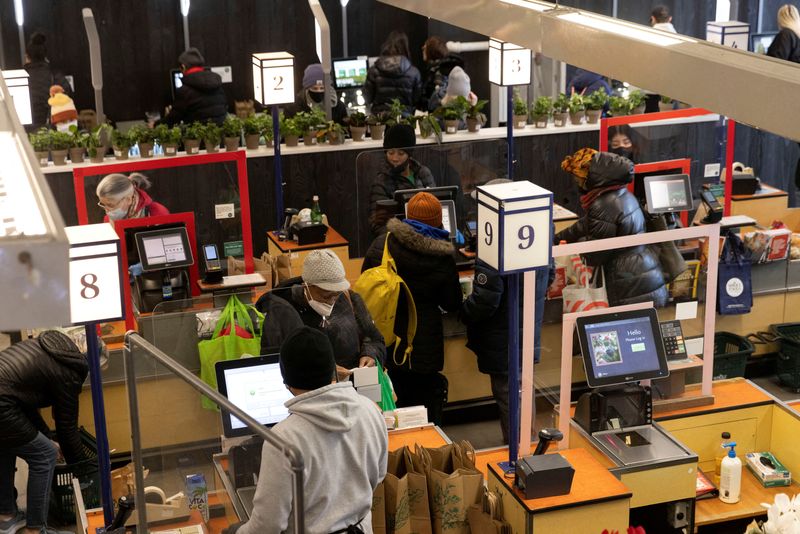 FILE PHOTO: People pay for their purchases at a supermarket
