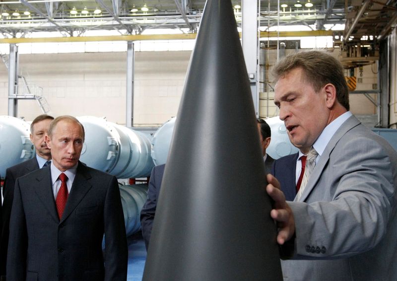 FILE PHOTO: Russian Prime Minister Putin listens to CEO of