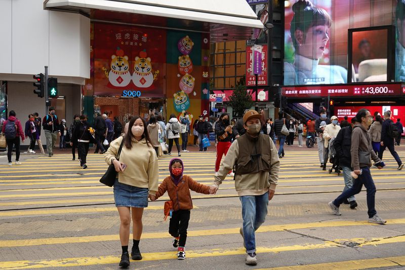 FILE PHOTO: Pedestrians wearing face masks cross a street in