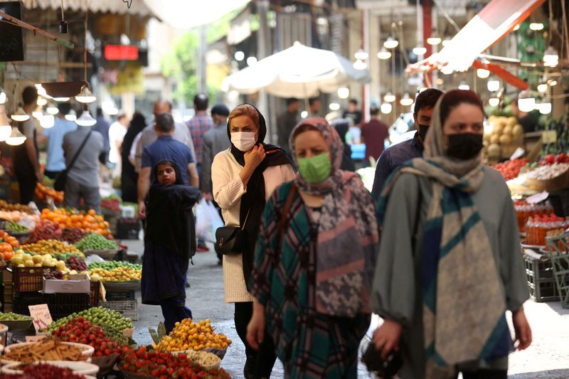 Iranians walk in a market in Tehran