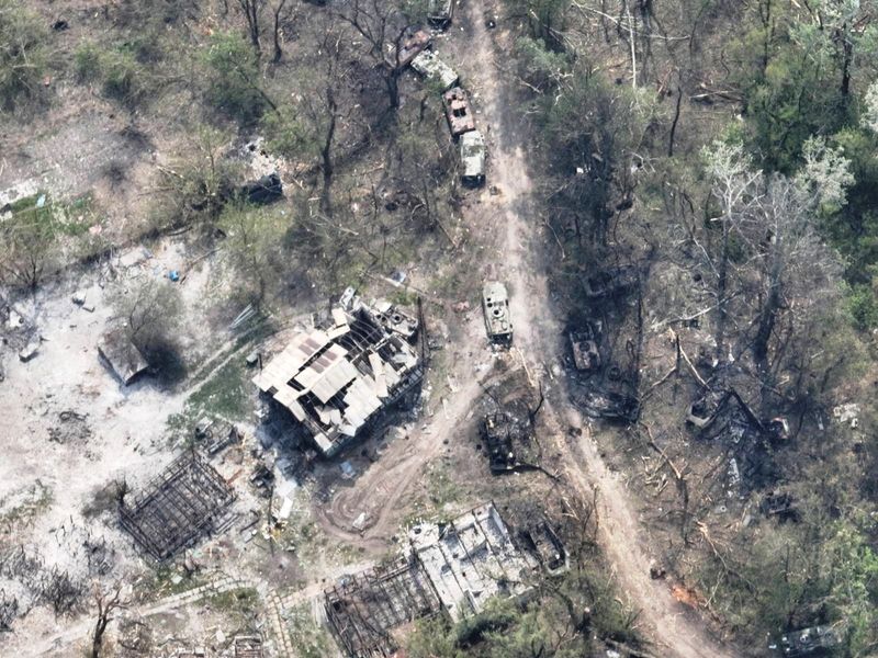 An aerial view of destroyed buildings and burnt vehicles on