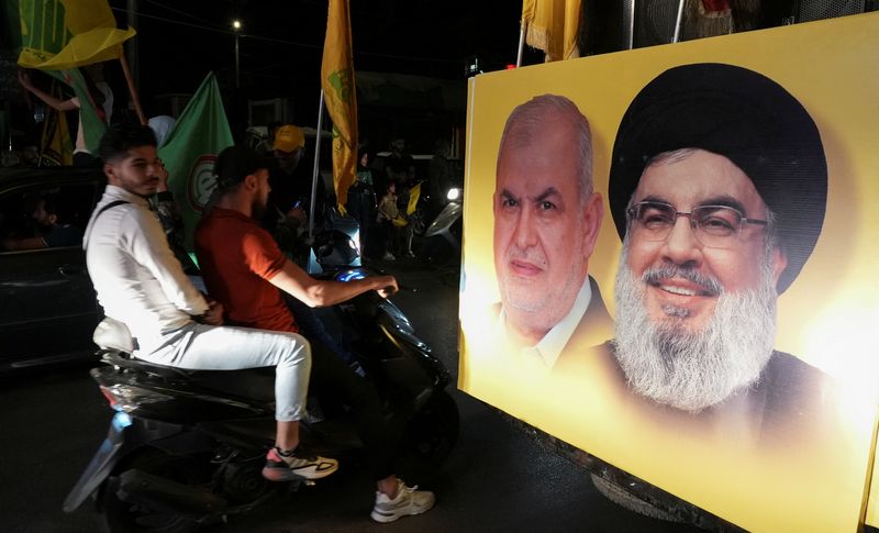 Supporters carry Hezbollah and Amal Movement flags as they ride