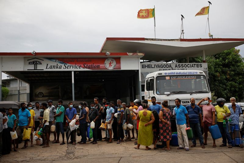 FILE PHOTO: People wait in a queue to buy petrol