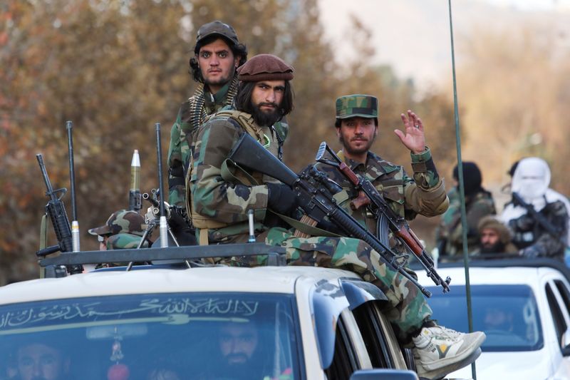 FILE PHOTO: Members of Taliban sit on a military vehicle