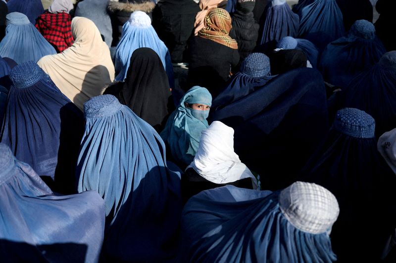 FILE PHOTO: People wait to receive bread in Kabul