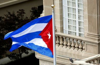 Cuban flag flutters in wind after being raised at embassy
