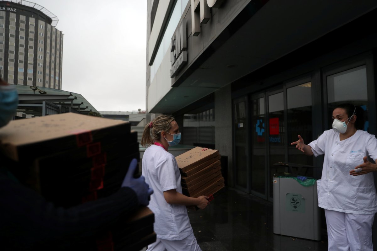 Medical staff at La Paz Hospital carry the 20 pizzas