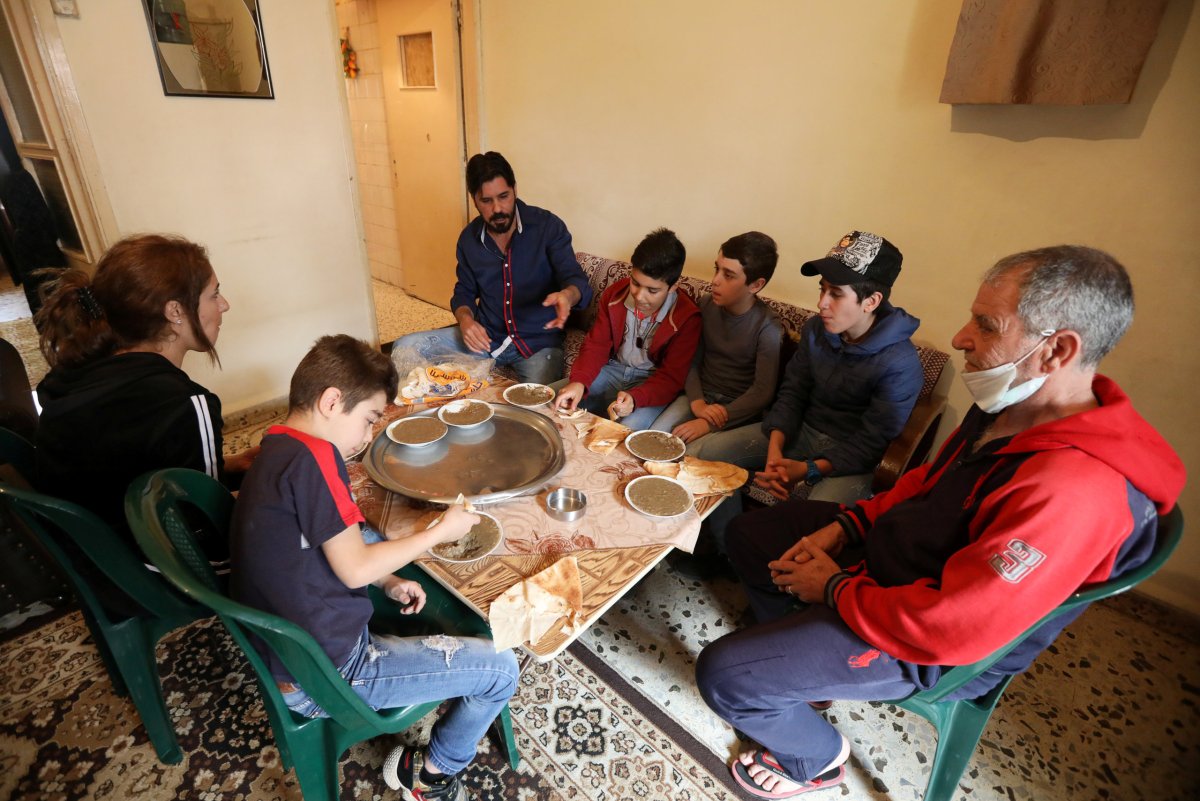 Hassan Zeitar, 39, eats with his family inside his home