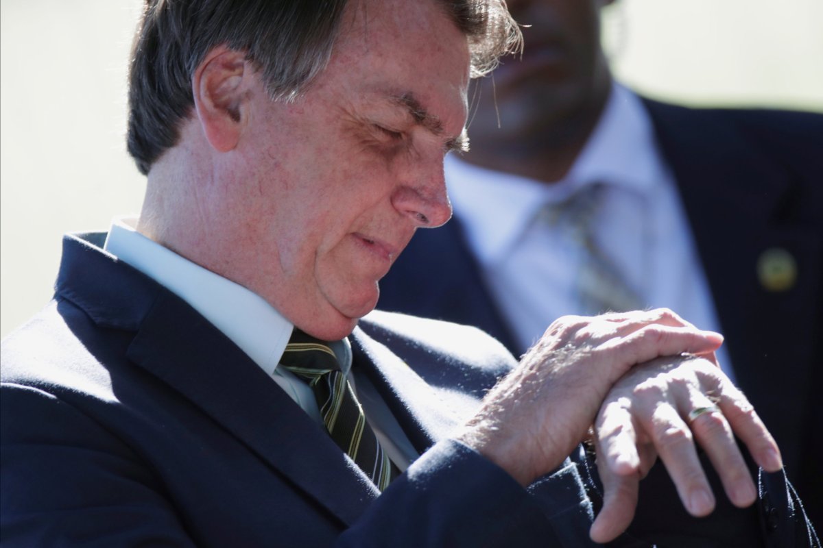 Brazil’s President Jair Bolsonaro looks at his watch while meeting