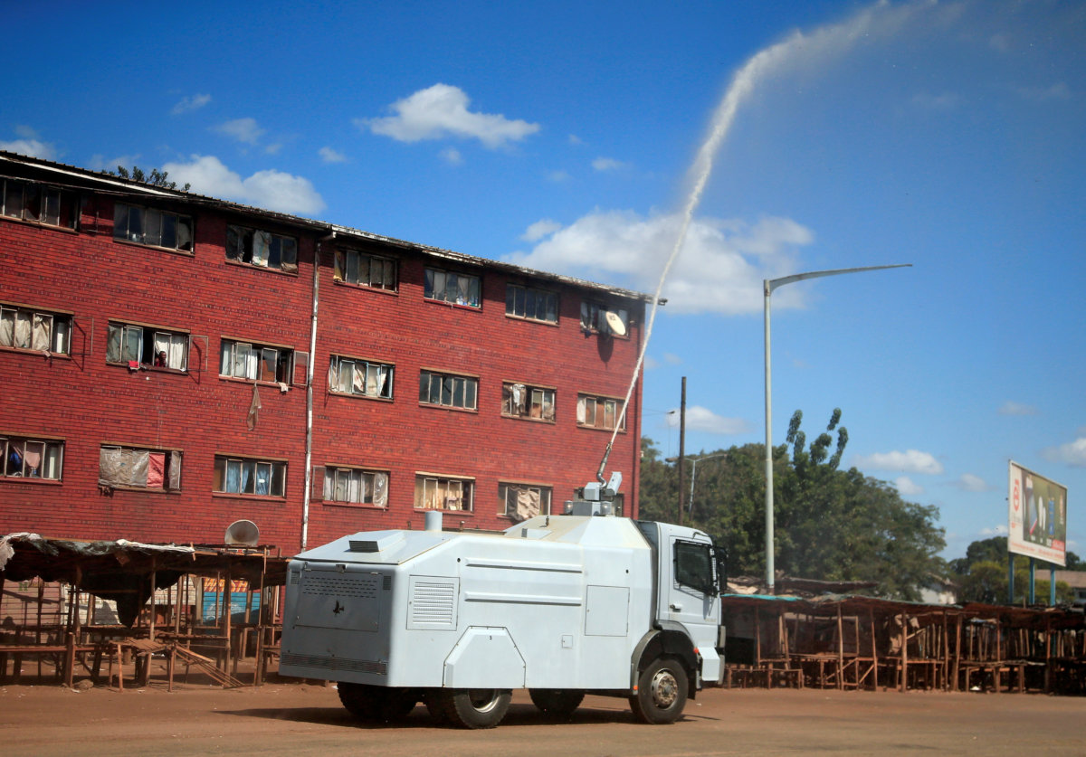 A police water canon sprays disinfectant over residential flats during