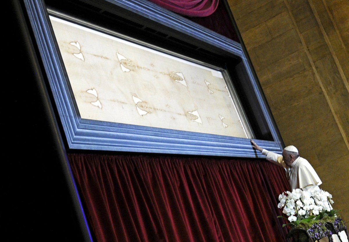 FILE PHOTO: Pope Francis touches the Shroud of Turin during