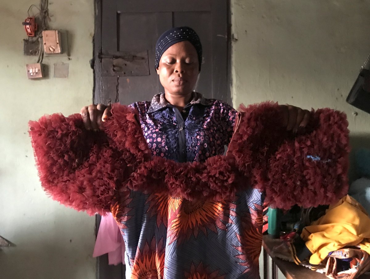 Kemi Adepoju, a dressmaker,  poses with a dress in